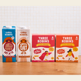 Three Robins Choccoriffic and Barista oat milk cartons beside multipack boxes of Super Berry Little Smoothies and Totally Tropical Little Smoothies
