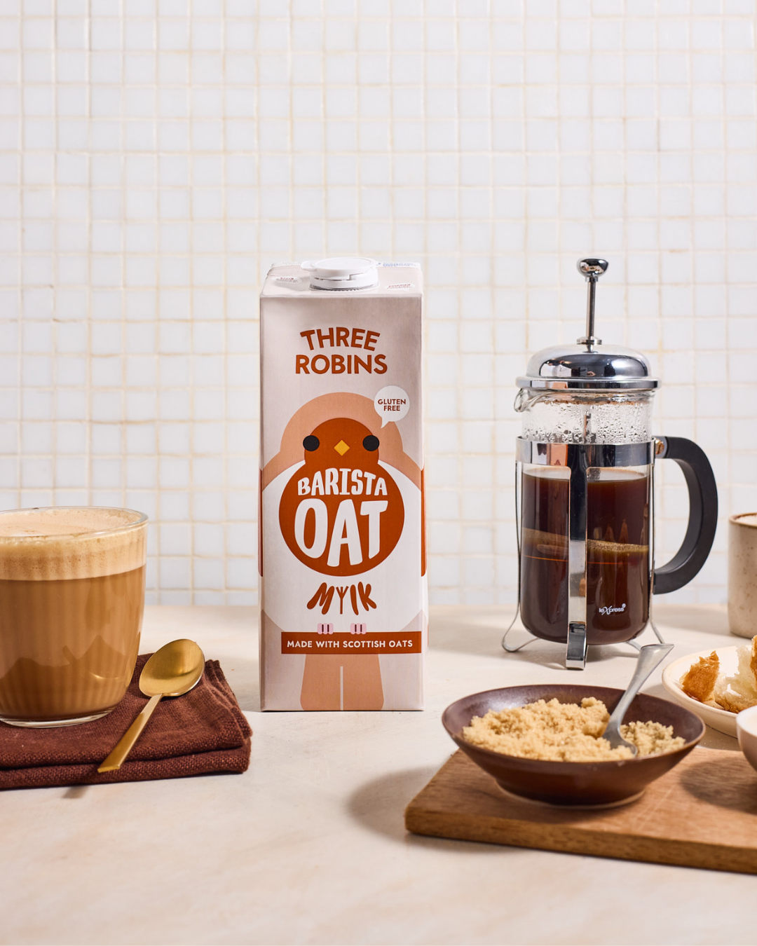 Three Robins Barista oat milk beside coffee in glass, bowl of sugar and a coffee cafetière