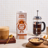 Three Robins Barista oat milk beside coffee in glass, bowl of sugar and a coffee cafetière