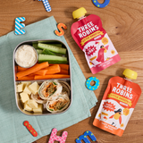 Three Robins Super Berry and Totally Tropical Little Smoothie pouches beside kids spelling letters and kids lunch box filled with snacks